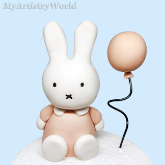 Handmade edible Miffy bunny cake topper sitting with a balloon for birthday and baby shower cakes